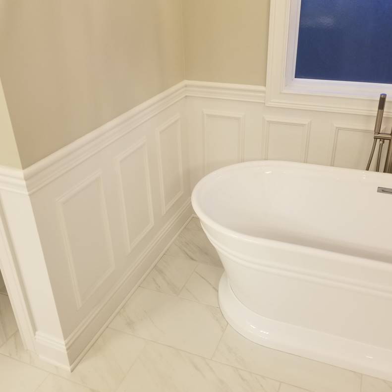 A bathroom with a white tub sitting next to a window

Description automatically generated