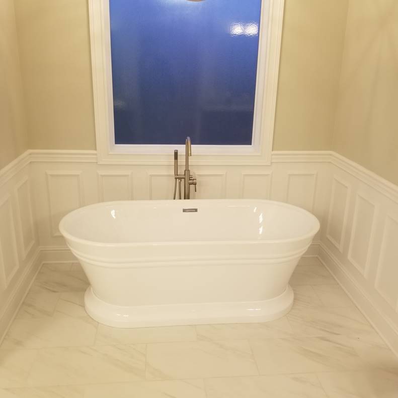 A bathroom with a white tub sitting next to a sink

Description automatically generated