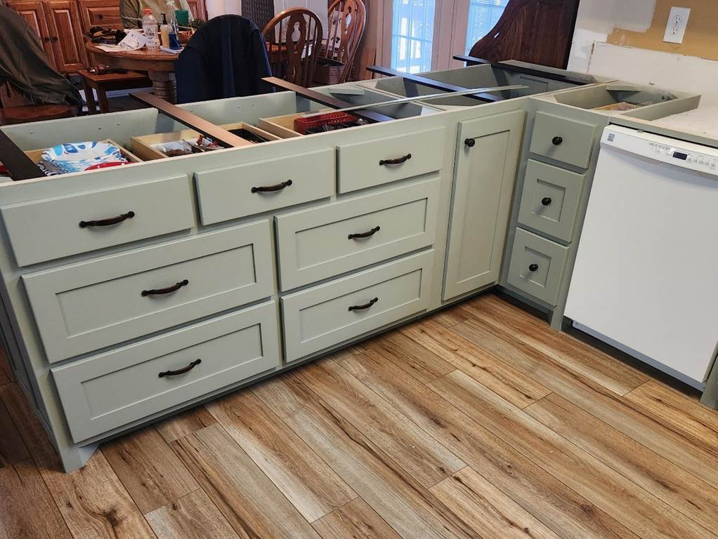 A kitchen with a wood floor

Description automatically generated