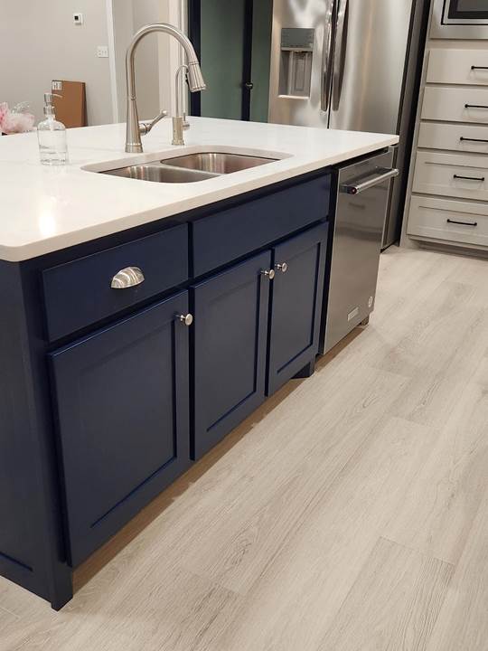 A kitchen with a sink and refrigerator

Description automatically generated
