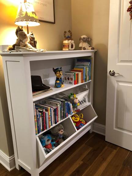 A room with a book shelf

Description automatically generated
