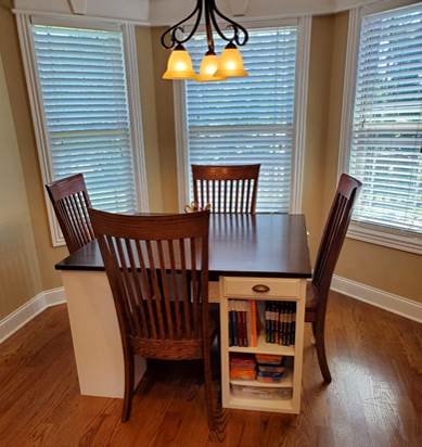 A kitchen with wooden cabinets and a dining room table

Description automatically generated